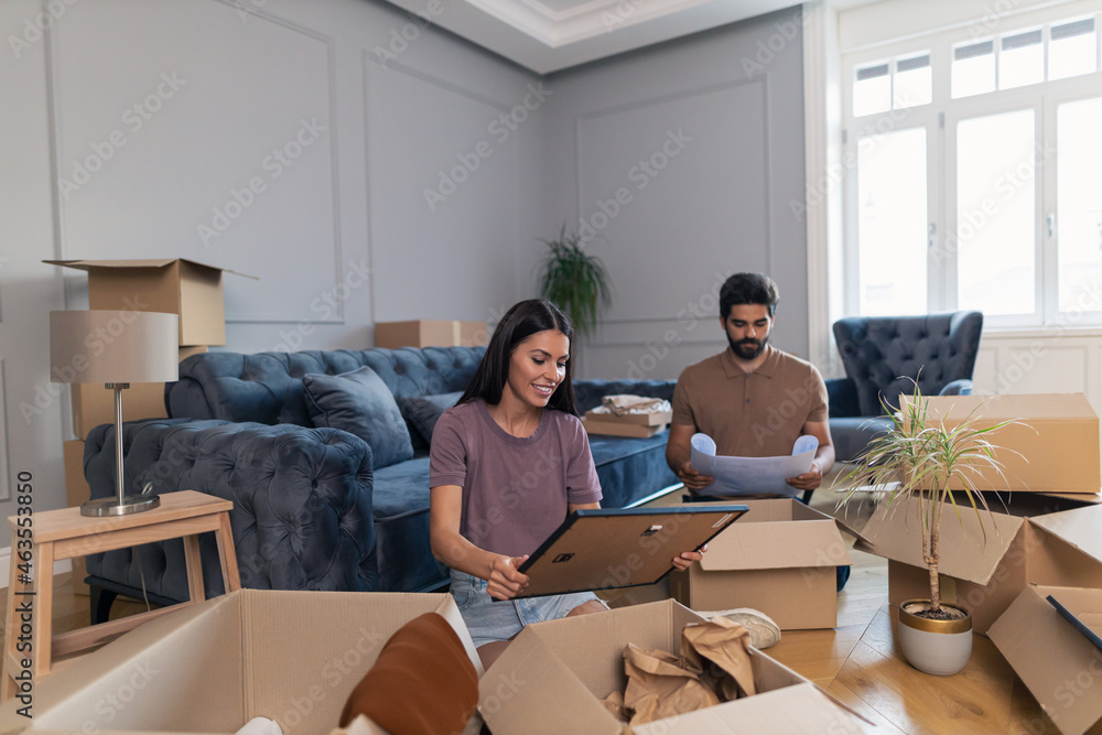 Couple unpacking their belongings at new apartment. Couple unpacking their belongings at new apartment.