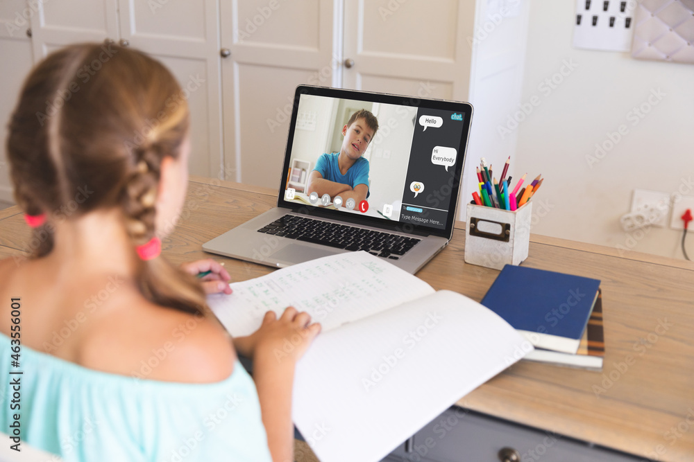 Caucasian girl using laptop for video call, with elementary school pupil on screen Caucasian girl using laptop for video call, with elementary school pupil on screen