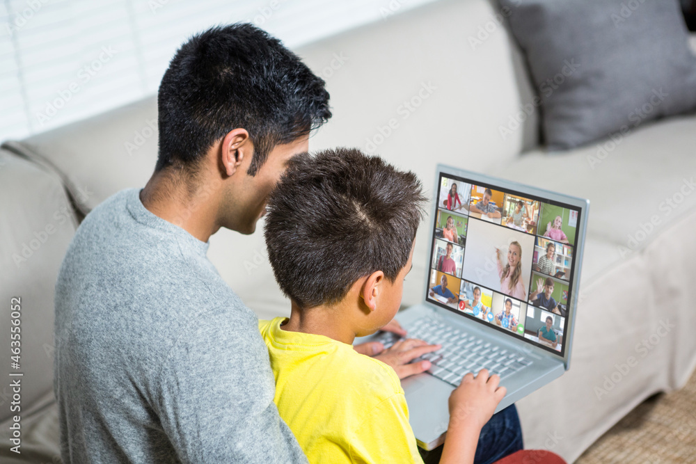 Obraz premium Biracial boy with father using laptop for video call, with elementary school pupils on screen