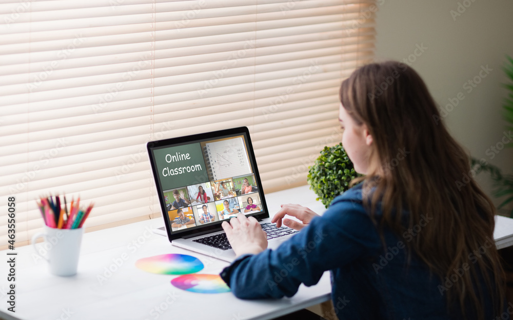Caucasian girl using laptop for video call, with smiling diverse elementary school pupils on screen Caucasian girl using laptop for video call, with smiling diverse elementary school pupils on screen