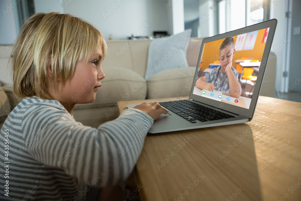 Caucasian boy using laptop for video call, with elementary school pupil on screen Caucasian boy using laptop for video call, with elementary school pupil on screen