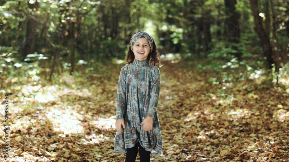 A little girl schoolgirl runs through the park. Educated kids. Portrait happy kids running near autumn forest and looking at camera. Kids have fun in the open air. Childhood concept A little girl schoolgirl runs through the park. Educated kids. Portrait happy kids running near autumn forest and looking at camera. Kids have fun in the open air. Childhood concept