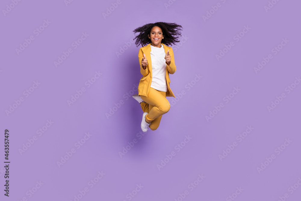 Photo of cheerful positive lady wear yellow suit glasses jumping high pointing fingers you isolated purple color background - obrazy, fototapety, plakaty 
