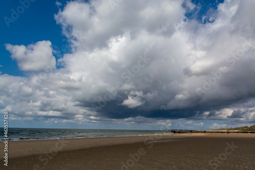 Fototapeta Naklejka Na Ścianę i Meble -  Walking on white sandy North sea beach near Zoutelande, Zeeland, Netherlands before thunderstorm
