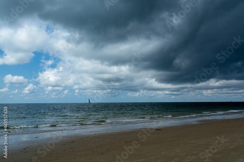 Walking on white sandy North sea beach near Zoutelande  Zeeland  Netherlands before thunderstorm