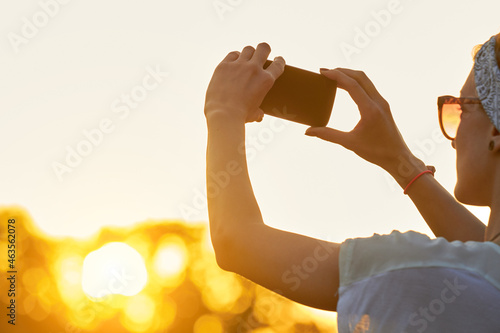 Female using modern smartphone outdoors. © astrosystem