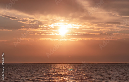 Colorful red sunset and bright sun on the horizon of the ocean beach. © Yuliia Lakeienko