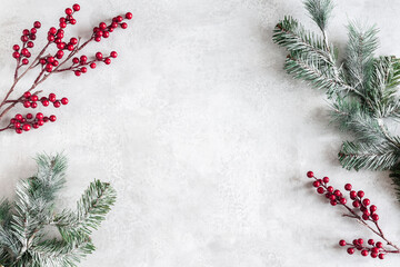 Christmas composition. Fir tree branches, red berries on gray background. Christmas, winter, new year concept. Flat lay, top view, copy space
