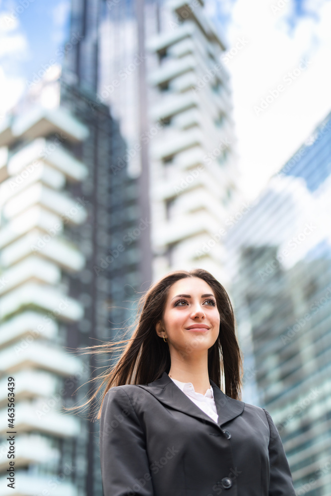 Smiling woman in front of her office in a modern city Smiling woman in front of her office in a modern city