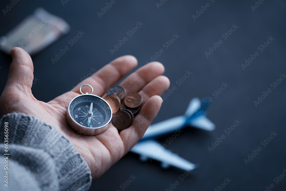 Travel concept. Magnetic compass in the hand. Retro navigator in hand a map and airplane background. Adventure Background. Travel concept. Magnetic compass in the hand. Retro navigator in hand a map and airplane background. Adventure Background.