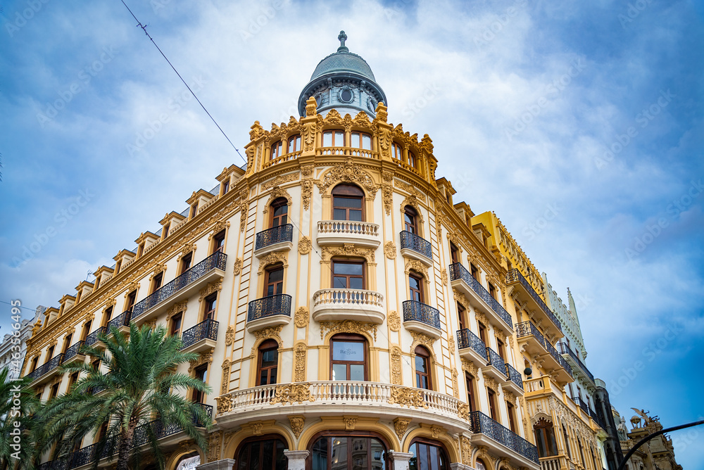 Obraz premium Corner of an elegant historical building in the city centre of Valencia, Spain. Blue sky with white clouds on the background.