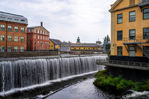 Cityscape of old industrial buildings with waterfall and water reservoir in the city of Norrkoping Sweden.