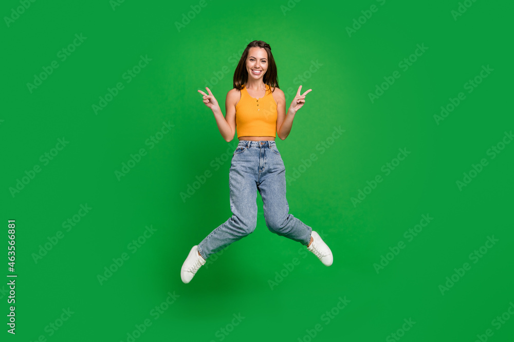 Full body photo of millennial cool brunette lady jump wear top jeans shoes isolated on green background Full body photo of millennial cool brunette lady jump wear top jeans shoes isolated on green background