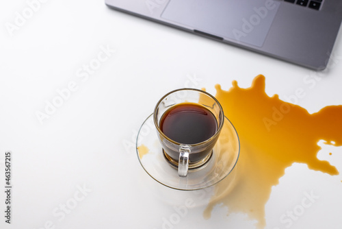 Bild auf Leinwand Black coffee beverage spilled near laptop
