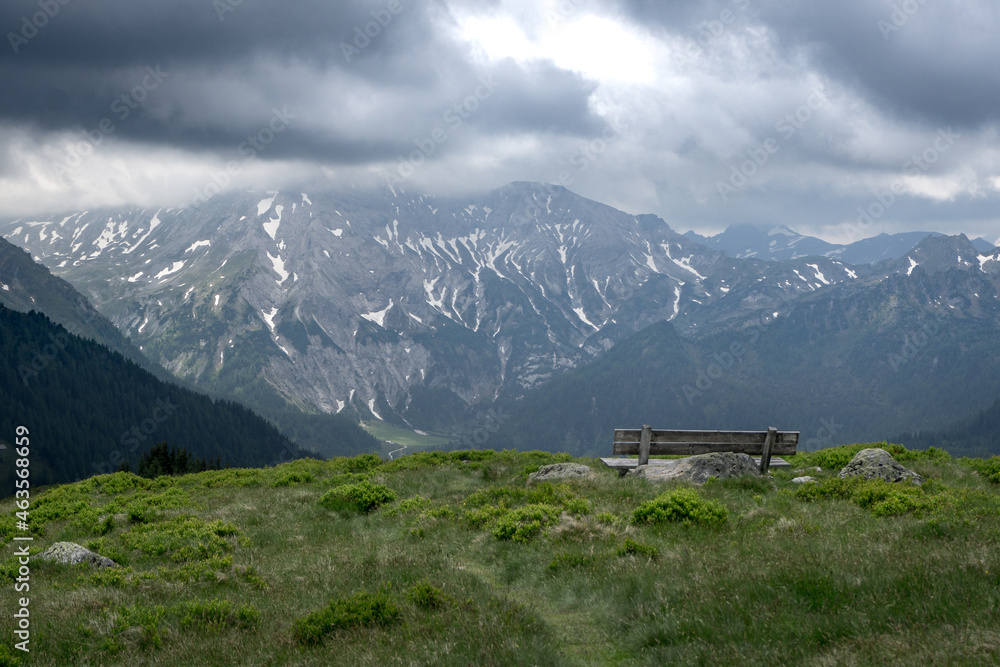 bench to rest on a high mountain with beautiful view over the austrian alps with dark cloudy sky