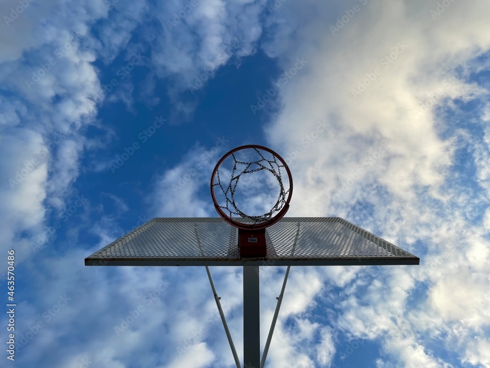 Basketball hoop seen from above with clouds and blue sky. Basketball hoop seen from above with clouds and blue sky.