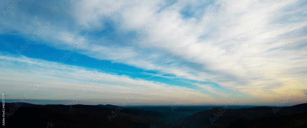 Morning sunrise over silhouetted mountains. Colorful cloud scape