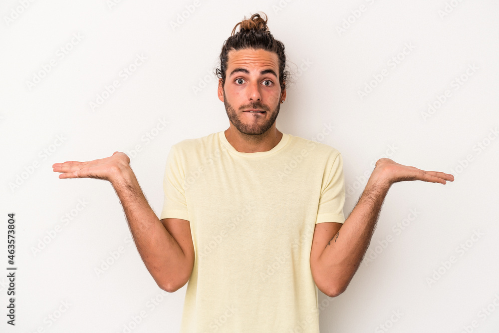 Young caucasian man isolated on white background confused and doubtful shrugging shoulders to hold a copy space. Young caucasian man isolated on white background confused and doubtful shrugging shoulders to hold a copy space.