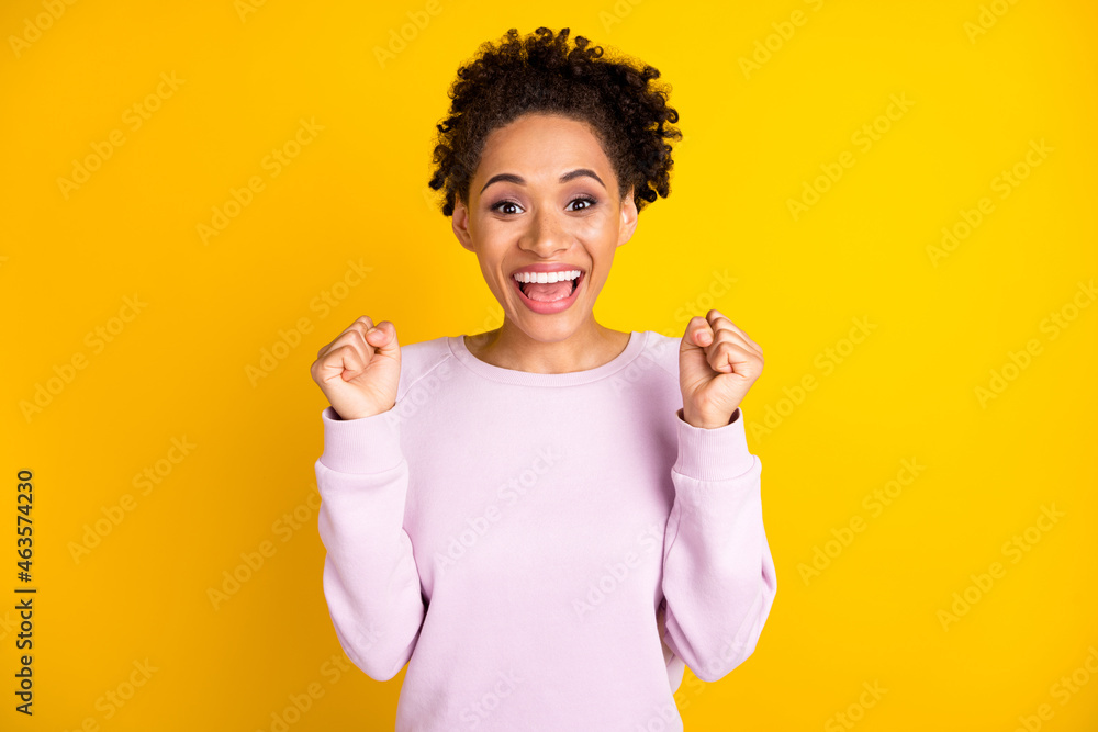 Photo of young happy dark skin woman winner celebrate excited good mood isolated on yellow color background Photo of young happy dark skin woman winner celebrate excited good mood isolated on yellow color background