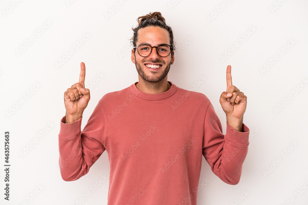 Young caucasian man isolated on white background indicates with both fore fingers up showing a blank space. Young caucasian man isolated on white background indicates with both fore fingers up showing a blank space.