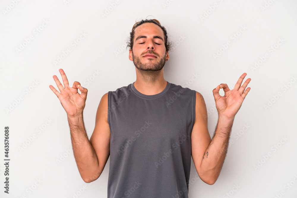 Naklejka premium Young caucasian man isolated on gray background relaxes after hard working day, she is performing yoga.