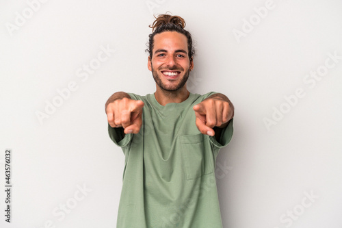 Young caucasian man isolated on gray background cheerful smiles pointing to front. photo