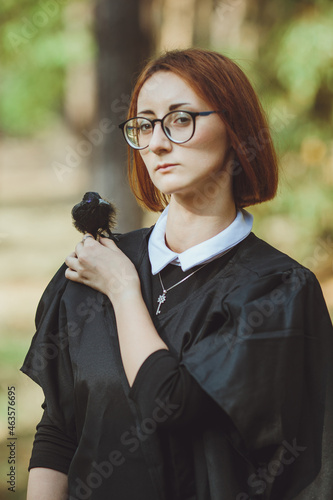 Obraz na płótnie Halloween witch. Portrait of a girl in a hat and witch costume and with a black raven in the forest. Ready for the holiday wallet or life
w salonie