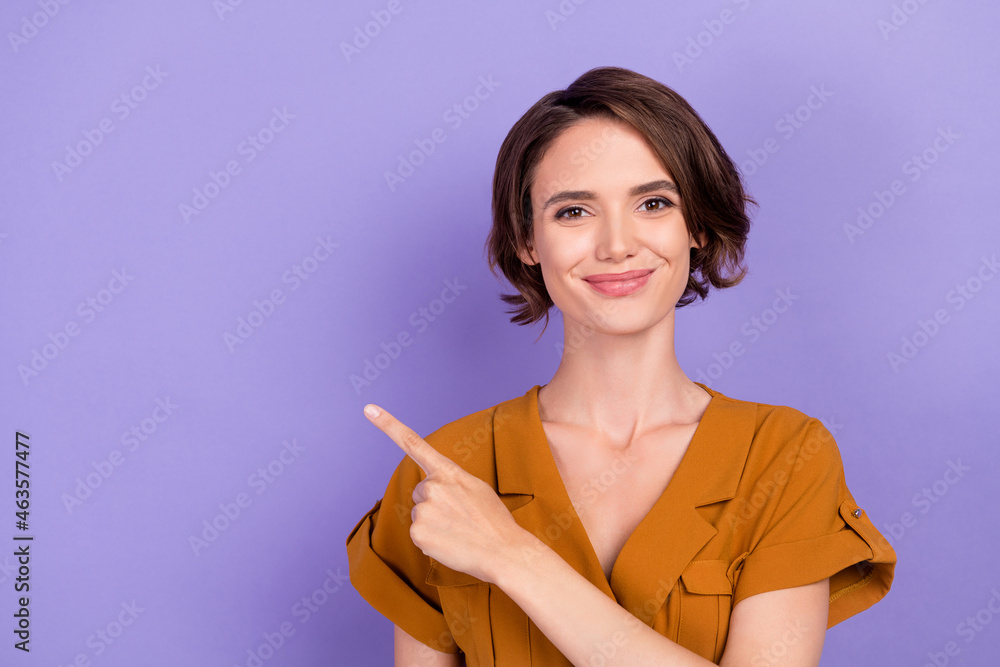Photo of young woman happy positive smile point finger empty space ad choice sale isolated over violet color background Photo of young woman happy positive smile point finger empty space ad choice sale isolated over violet color background