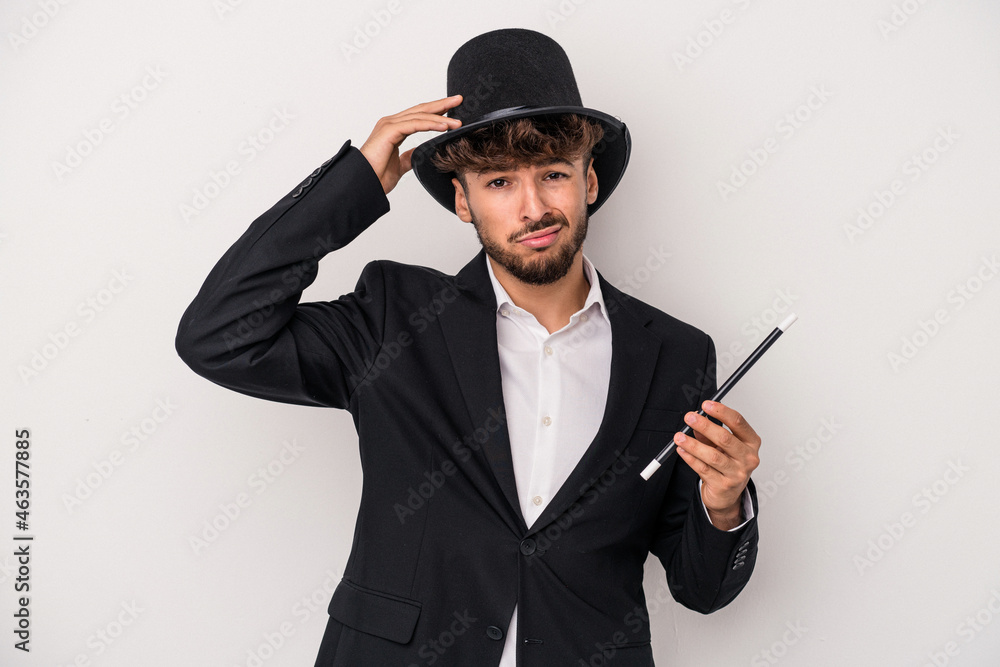 Young arab wizard man holding a wand isolated on white background being shocked, she has remembered important meeting. Young arab wizard man holding a wand isolated on white background being shocked, she has remembered important meeting.