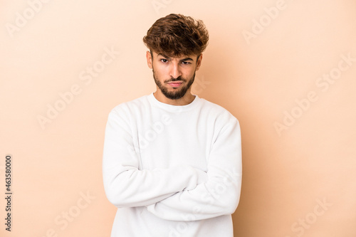 Young arab man isolated on beige background unhappy looking in camera with sarcastic expression.