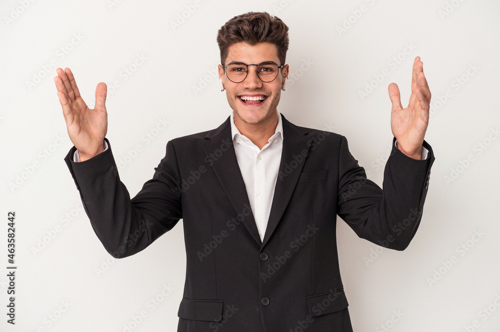 Young business caucasian man wearing headphones isolated on white background receiving a pleasant surprise, excited and raising hands. Young business caucasian man wearing headphones isolated on white background receiving a pleasant surprise, excited and raising hands.