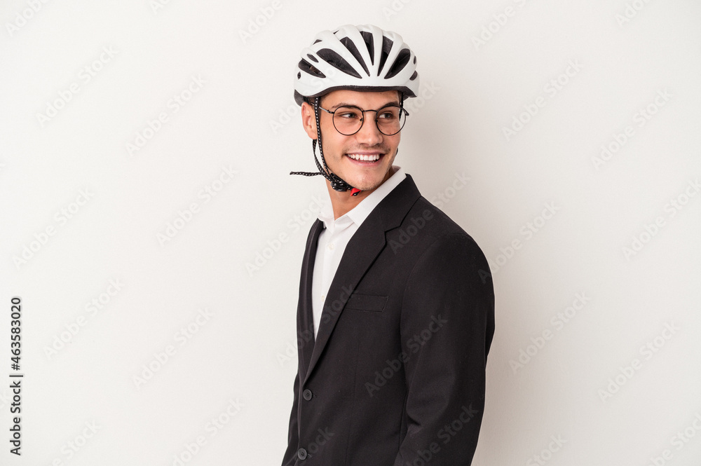 Young business caucasian man holding bike helmet isolated on white background looks aside smiling, cheerful and pleasant. Young business caucasian man holding bike helmet isolated on white background looks aside smiling, cheerful and pleasant.