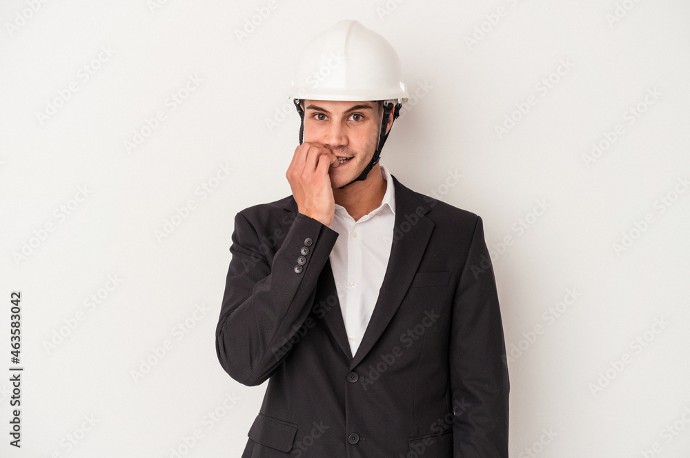 Young architect caucasian man isolated on white background biting fingernails, nervous and very anxious.