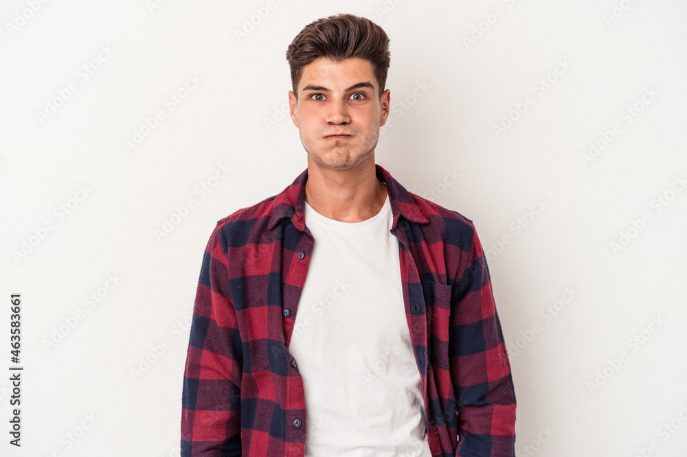 Young caucasian man isolated on white background blows cheeks, has tired expression. Facial expression concept. Young caucasian man isolated on white background blows cheeks, has tired expression. Facial expression concept.