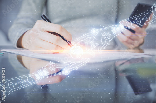 Double exposure of technology sketch hologram and woman holding and using a mobile device.