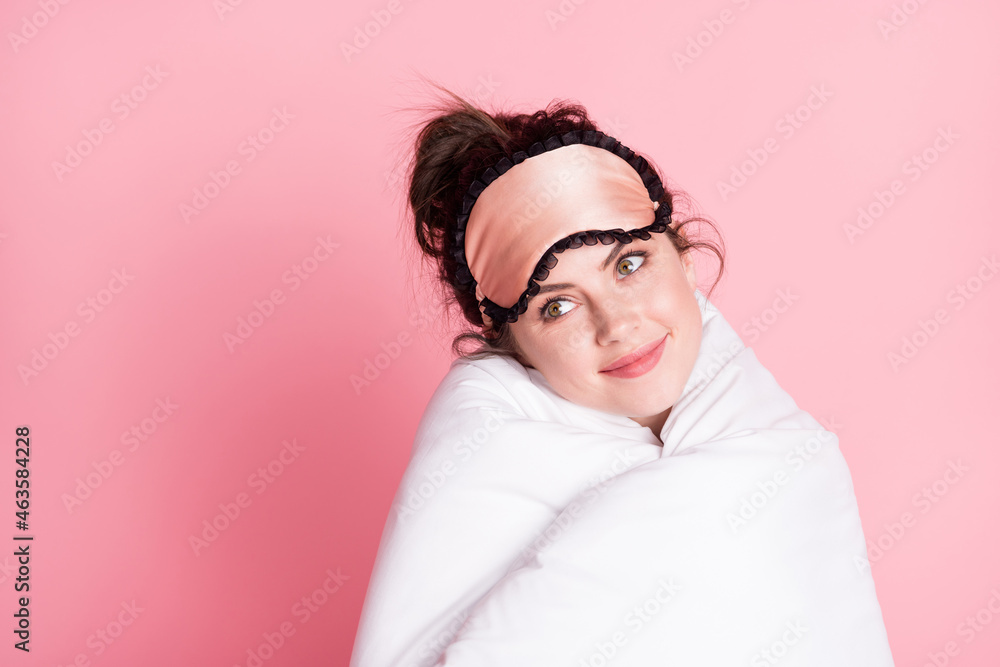 Photo portrait of girl in sleeping mask cuddle herself in white soft blanket isolated on pastel pink color background Photo portrait of girl in sleeping mask cuddle herself in white soft blanket isolated on pastel pink color background