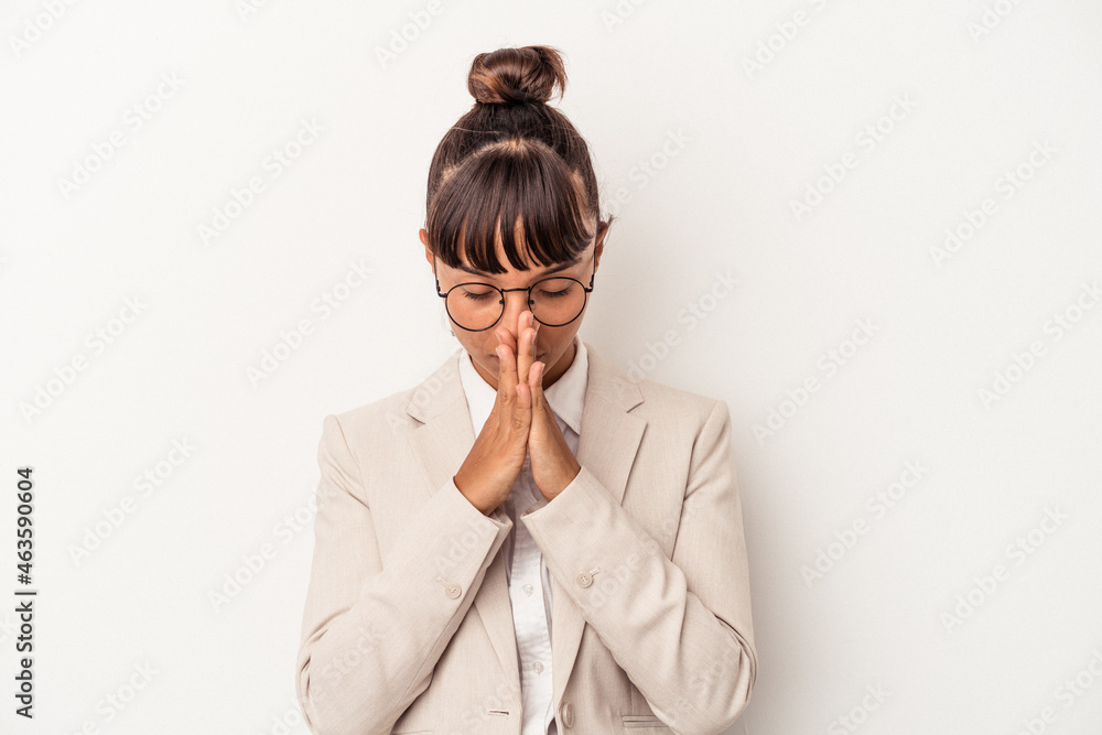 Young mixed race woman isolated on white background praying, showing devotion, religious person looking for divine inspiration. Young mixed race woman isolated on white background praying, showing devotion, religious person looking for divine inspiration.