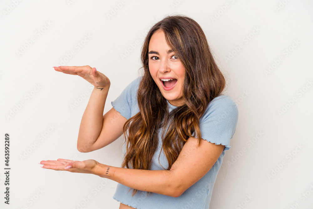Young caucasian woman isolated on white background shocked and amazed holding a copy space between hands. Young caucasian woman isolated on white background shocked and amazed holding a copy space between hands.