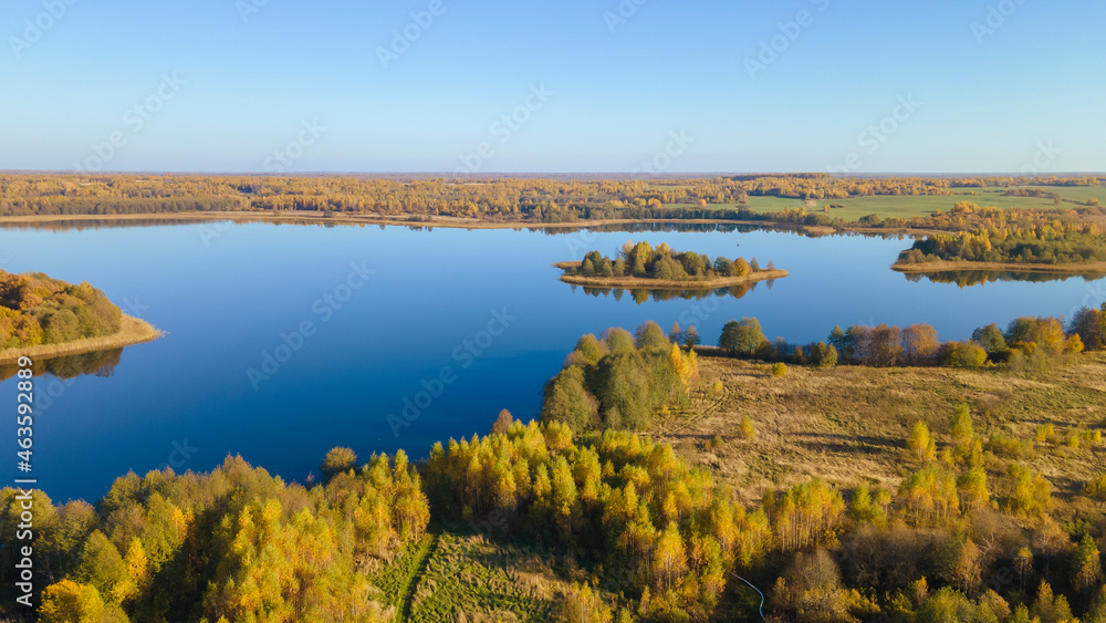 Fototapeta premium Autumn forest and lake. View from the top. Aerial Photo of an Island in Lake on Sunny Autumn Day.