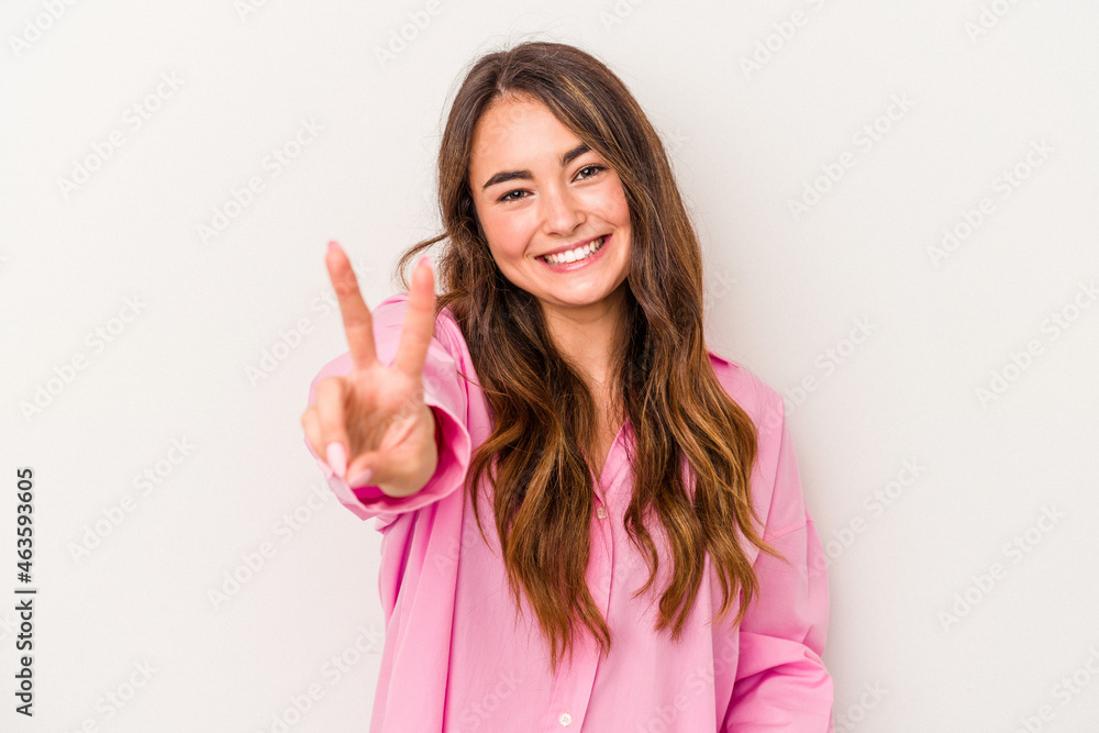 Young caucasian woman isolated on white background joyful and carefree showing a peace symbol with fingers. Young caucasian woman isolated on white background joyful and carefree showing a peace symbol with fingers.