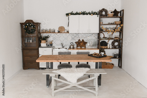 New Year's kitchen interior design in a light Scandinavian style with a table and decoration made of natural materials, garlands, oranges, holiday © Svetlana
