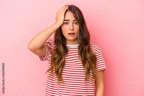 Young caucasian woman isolated on pink background being shocked, she has remembered important meeting.