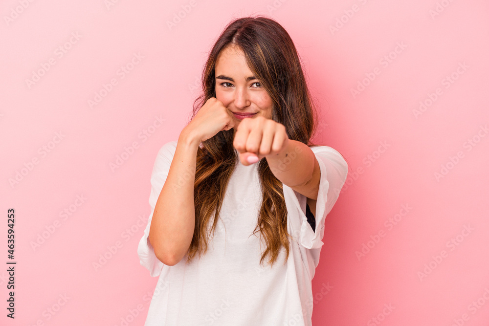 Young caucasian woman isolated on pink background throwing a punch, anger, fighting due to an argument, boxing. Young caucasian woman isolated on pink background throwing a punch, anger, fighting due to an argument, boxing.