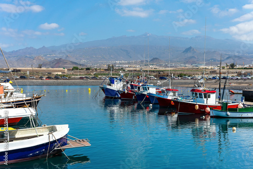 Las Galletas port with fishing boats with the Teide mountain in the background. In Tenerife. Canary Islands.