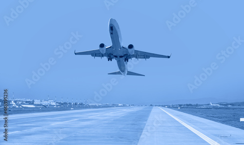 White Passenger plane fly up over take-off runway from airport 