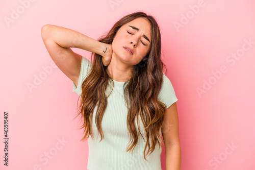 Young caucasian woman isolated on pink background massaging elbow  suffering after a bad movement.