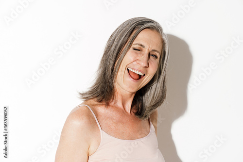Mature grey woman laughing and winking at camera