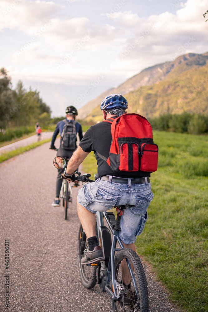 Father and son riding ebike and mountainbike on bikeway in Terlan, Southtyrol Italy; healthy active lifestyle concept Father and son riding ebike and mountainbike on bikeway in Terlan, Southtyrol Italy; healthy active lifestyle concept