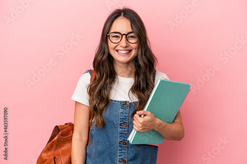 Young caucasian student woman isolated on pink background laughing and having fun.