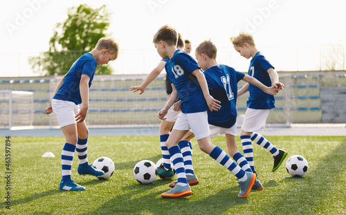 Football Team in Blue Soccer Uniforms on Training Class With Balls. Kids Kicking Balls on Grass Venue. Soccer Class For School Kids © matimix